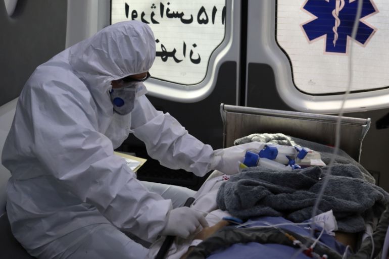 A member of emergency medical staff wearing protective suit, sits in an ambulance while transferring a patient with coronavirus disease (COVID-19) to Masih Daneshvari Hospital, in Tehran