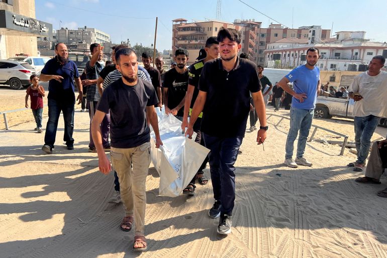 People carry the body of a dead Palestinian.