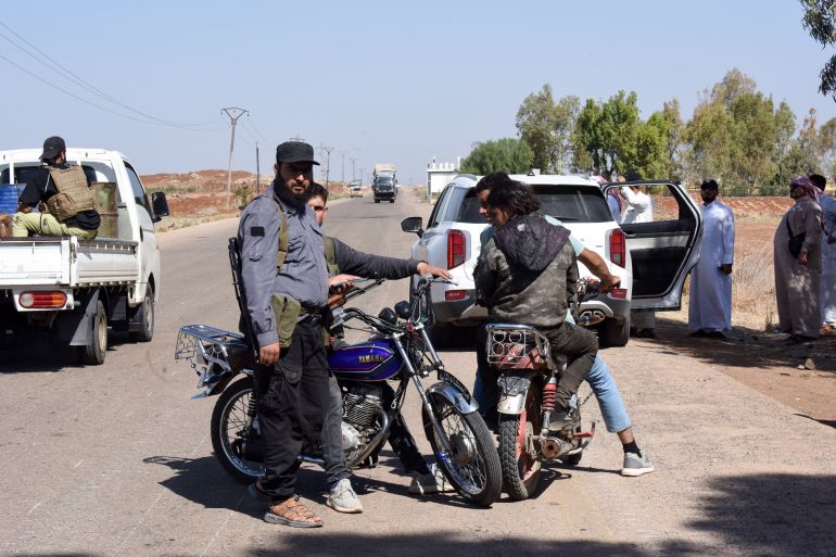 Fighters from Bedouin tribes gather along a road.